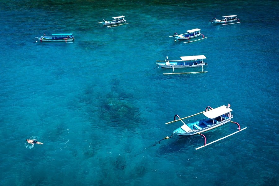 Vista por drones de barcos y nadadores en Crystal Bay en Nusa Penida, Bali