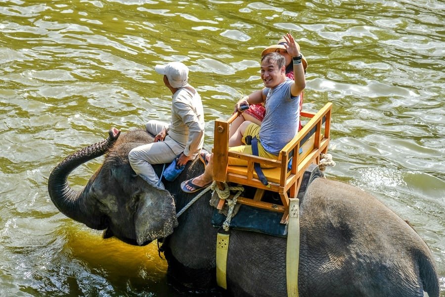 Turistas felices dando un paseo en elefante en el zoológico de Bali