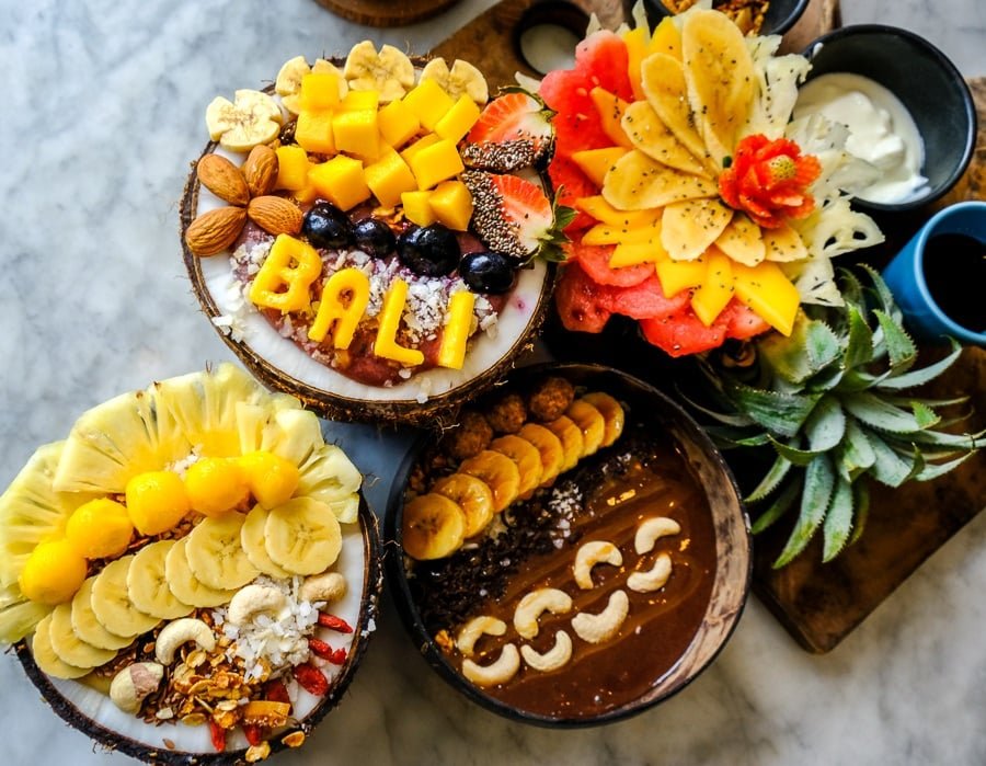 Tazones de batidos de frutas artísticos sobre una mesa en Cafe Organic en Canggu