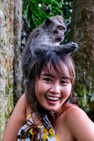 Niña sosteniendo un mono de Bali en el Bosque de Monos Sangeh