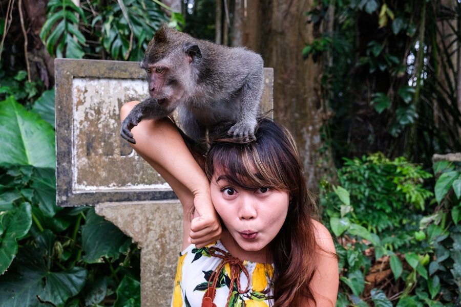 Chica sujetando un mono de Bali