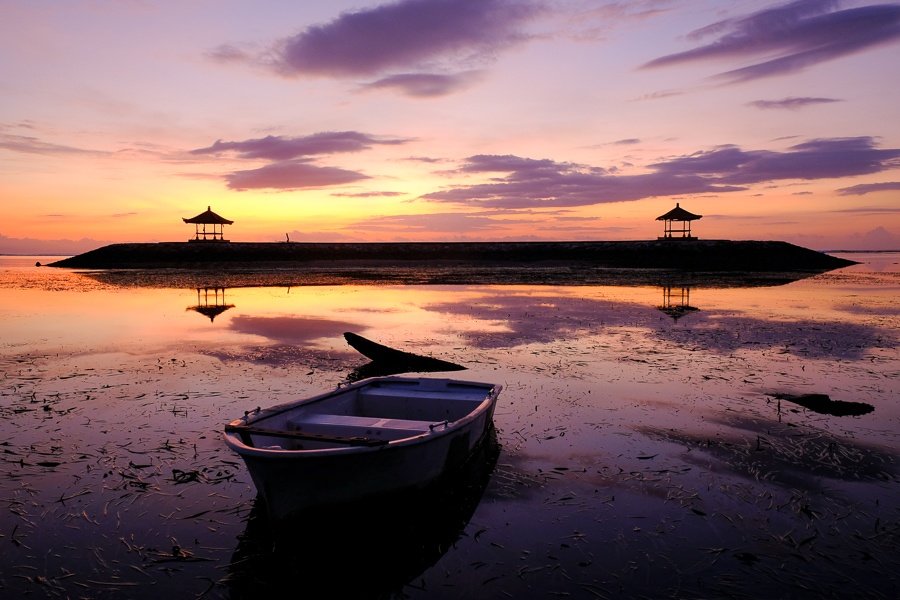 Reflexión del barco en un amanecer en la playa de Sanur en Bali