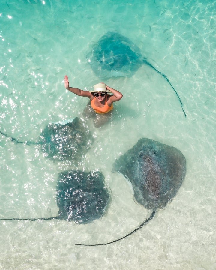 Mujer nadando con mantarrayas en la playa de Fulidhoo Maldivas