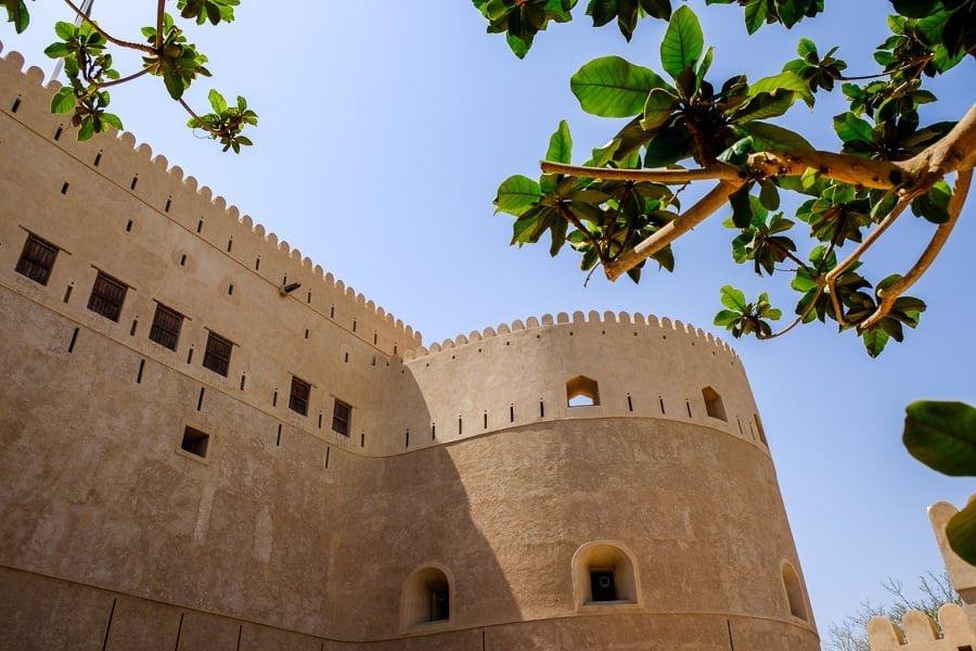 Mirando a través de los árboles las murallas del castillo de Al Hazm en Omán