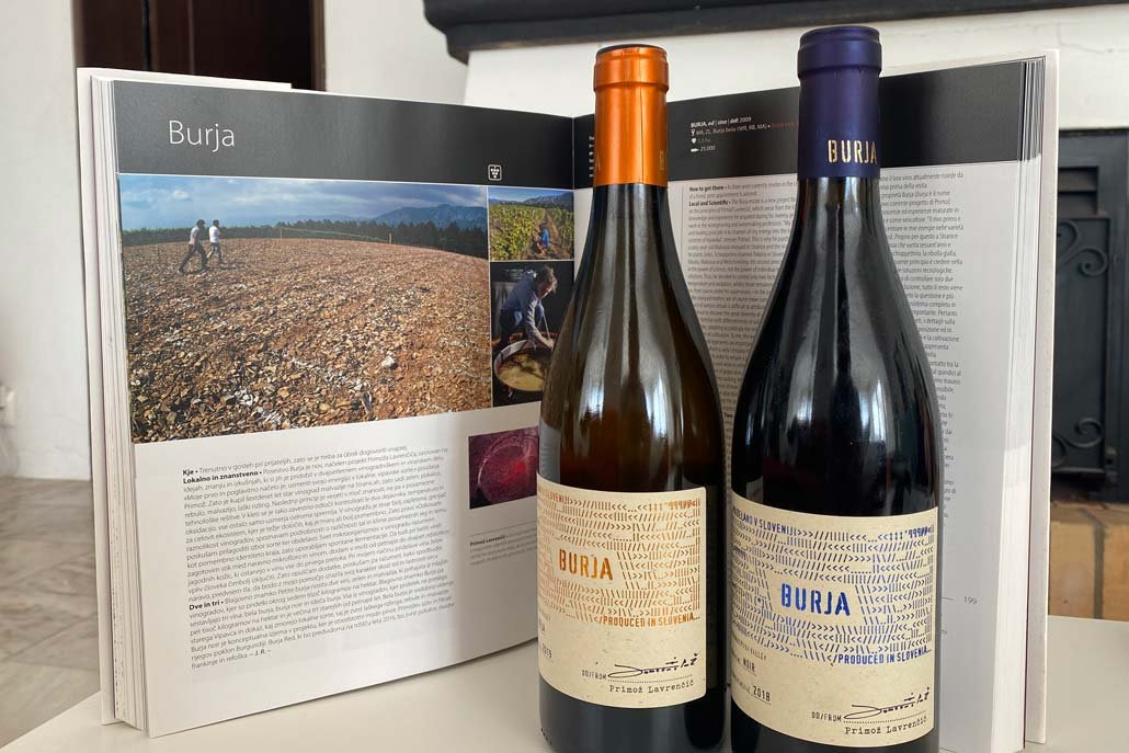 Dos botellas de vino de Burja delante de su descripción en un pesado libro de mesa de café.