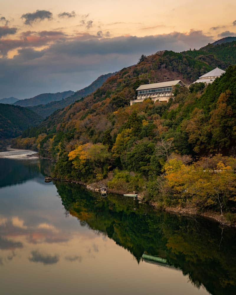 Un reflejo del atardecer del Hotel Siera Shimanto en el río